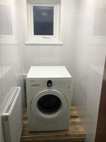 a washing machine in a room with a window at 106 Brynmill - Room 2 in Sketty