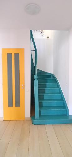 a blue staircase with a yellow door in a room at Σπίτι - Κάστρο πάνω από τη θάλασσα in Piraeus