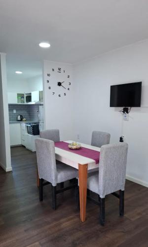 tavolo da pranzo con sedie e orologio sul muro di Arequito centro a Arequito