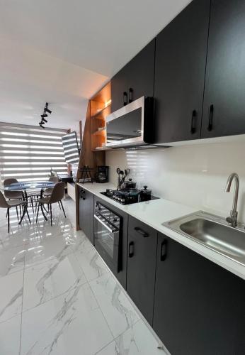 a kitchen with black cabinets and a table with chairs at Desing House Obarrio by G Housing in El Quije