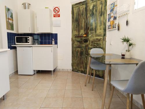 Una cocina con una mesa y una puerta de madera. en Happy Home, en Garachico