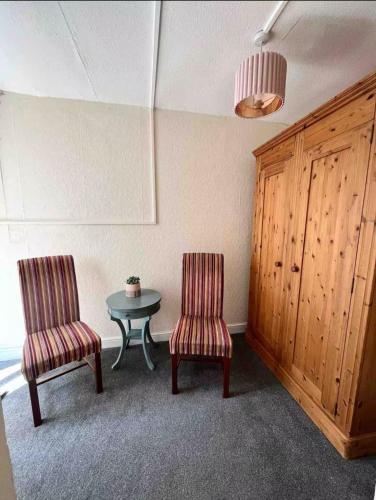 two chairs and a table in a room at 106 Brynmill - Room 3 in Sketty