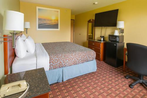 a hotel room with a bed and a flat screen tv at Days Inn by Wyndham Morton in Morton