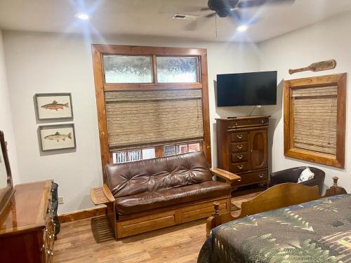 a bedroom with a leather chair and a window at Little Red River Chalet in Heber Springs