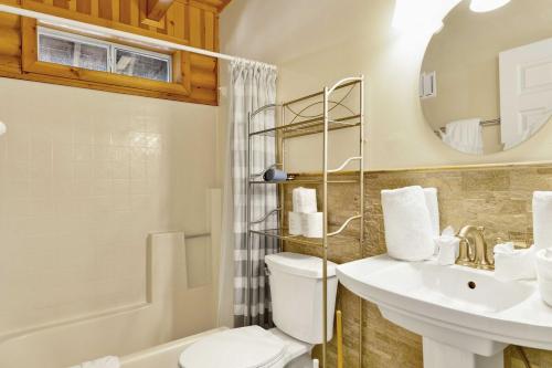 ein Badezimmer mit Toilette, Waschbecken und Spiegel in der Unterkunft Cub's Cabin / Charming 3-Bedroom Log Cabin Near Big Bear Lake in Big Bear Lake