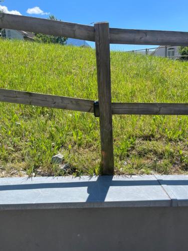 a wooden fence in front of a field of grass at Die möblierten Apartments in Triesen