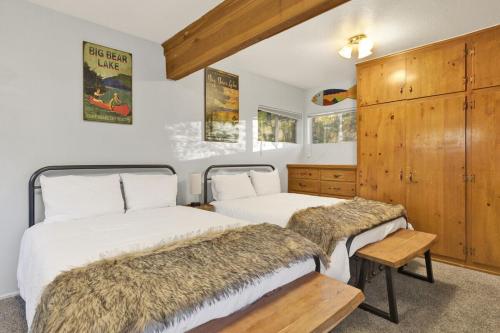 2 Betten in einem Zimmer mit Holzschränken in der Unterkunft Orchard Family Cabin Near Historic Big Bear Village Walk to Marina in Big Bear Lake