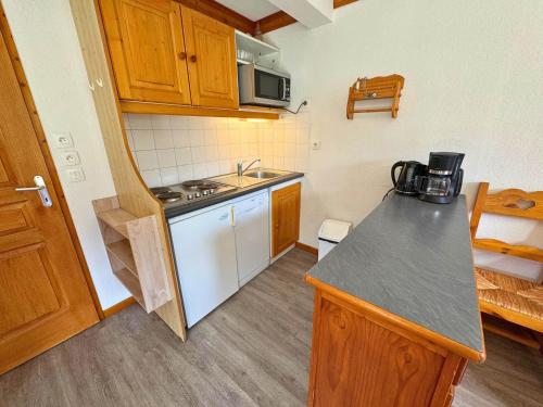 une petite cuisine avec un évier et une cuisinière dans l'établissement Appartement 2 chambres, balcon Sud-Ouest, Les Menuires - FR-1-452-235, aux Menuires