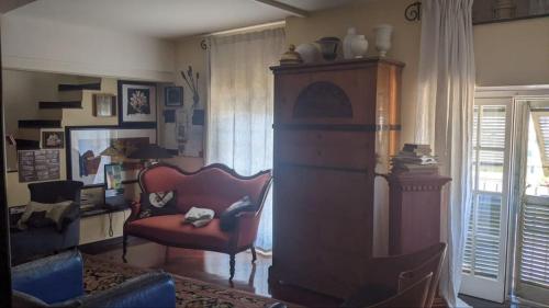 a living room with a red chair and a desk at Appartamento Esclusivo De Ferrari - Genova Centro Storico in Genova