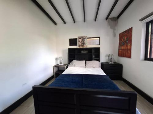 a bedroom with a large bed with a blue blanket at Casa de lujo wifi jacuzzi charcos parking in Barbosa