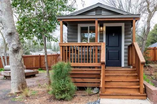 a tiny house with a deck and a black door at Columbia Cabins Cabin 2 in Sonora