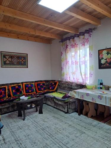 a living room with couches and tables and curtains at Ысык-Кол Чок-Тал in Chok-Tal