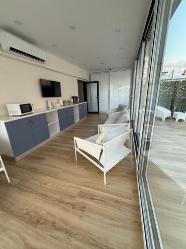 a living room with white furniture and a large window at Dimora Luminè in Naples