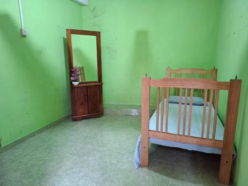 a bedroom with a wooden bed and a mirror at Tk Homestay in Talawakele