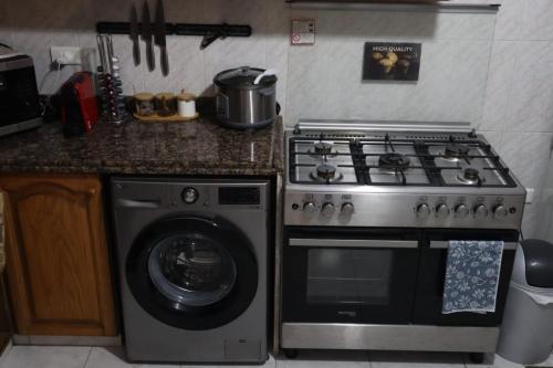 a kitchen with a stove and a washing machine at Casa El Haje in Al Maşyaf