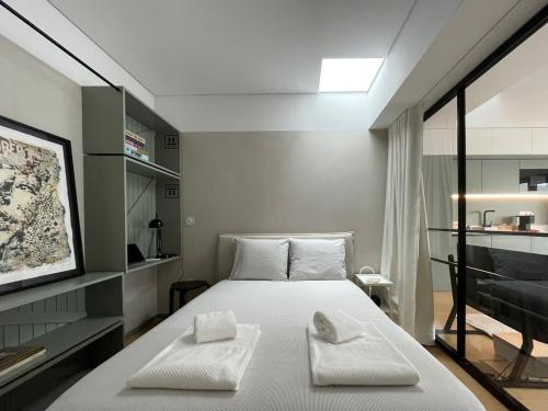 a bedroom with a bed with two towels on it at Green & Grey Loft in Matosinhos