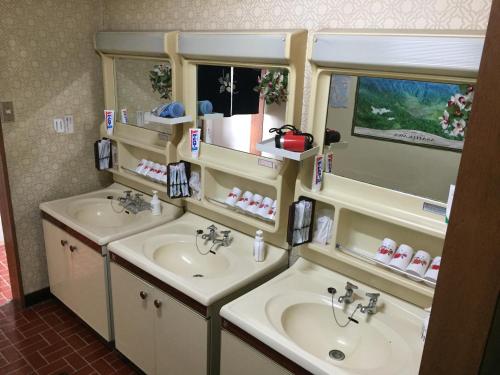 a bathroom with two sinks and two mirrors at Mimatsuso Ryokan in Asahikawa