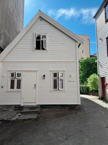 a white building with a door and a window at Nyrenovert Bergenshus med 2 leiligheter - rolig smau i hjertet av Bergen in Bergen