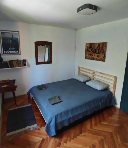 a bedroom with a large blue bed in a room at Bocke Beach House in Novi Sad