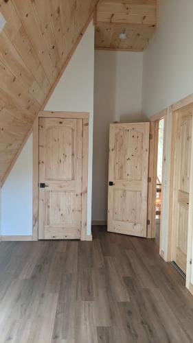 an empty room with two doors and wooden floors at Luxe Retreat - King Beds - Sept Dates! - Easy drive - XL Swim Spa - Award Winning! in Sevierville