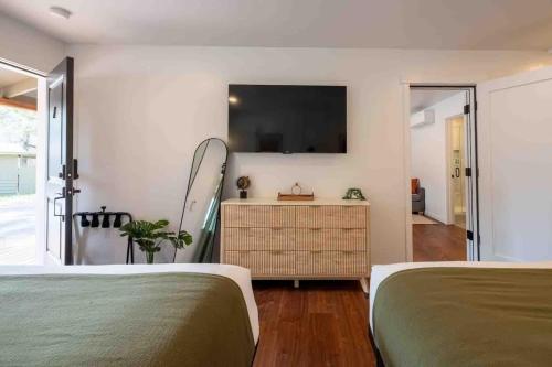 a bedroom with two beds and a television on the wall at Columbia Cabins Cabin 7 in Sonora