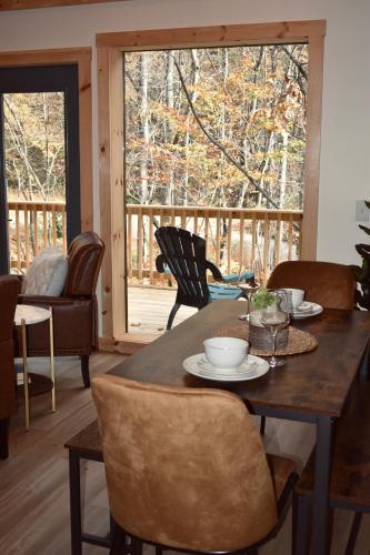 a dining room with a table and chairs and a large window at Luxe Retreat - King Beds - Sept Dates! - Easy drive - XL Swim Spa - Award Winning! in Sevierville