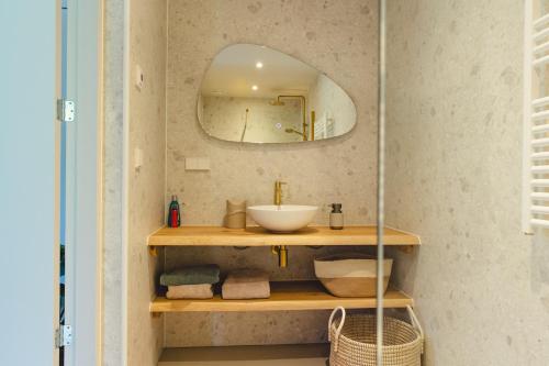 een badkamer met een wastafel en een spiegel bij Gastenverblijf Beekweide - de Notenboom in Voorst