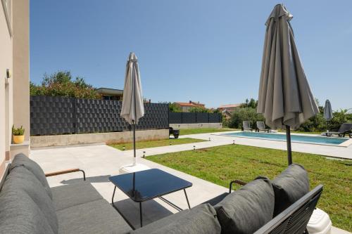 a living room with a couch and two umbrellas at Vita Laboris in Valtura