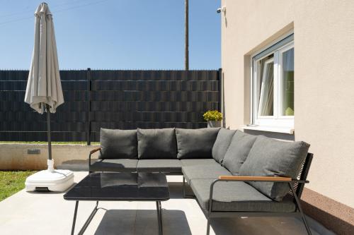a couch and an umbrella on a patio at Vita Laboris in Valtura