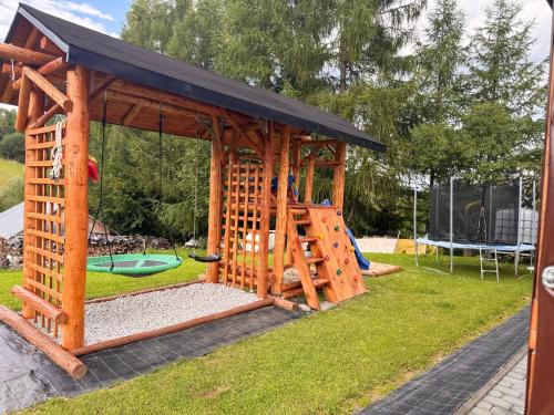 a wooden play structure with a playground at Bieszczadzki domek in Wola Matiaszowa