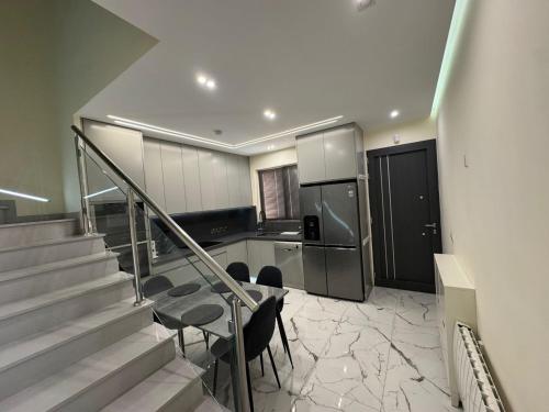 a kitchen with a staircase and a table and a refrigerator at Modern 2 bedroom Townhouse in Paphos City