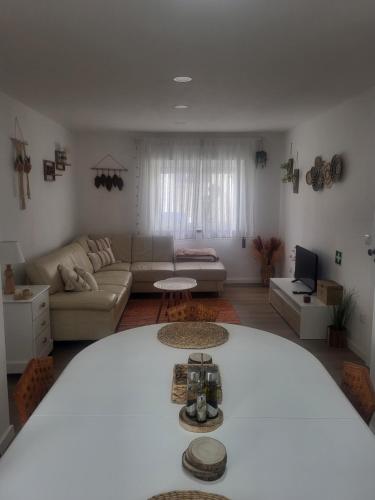 a living room with a couch and a table at Spring Water House in Olho Marinho