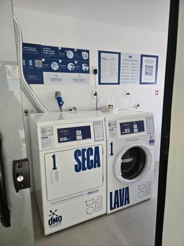 a washing machine in a room with a sign on it at Home Easy Flat in Volta Redonda