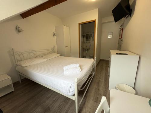 a small bedroom with a bed and a bathroom at Hôtel Le Bellevue in Ax-les-Thermes