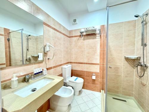 a bathroom with a toilet and a sink and a shower at Bel Ami Suita Hotel in Vlorë