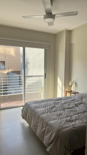 a bedroom with a large bed and a large window at Rincón de Barrio Sur in San Miguel de Tucumán