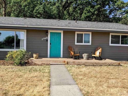 a house with two chairs and a blue door at Modern Gorge Lodge in The Dalles