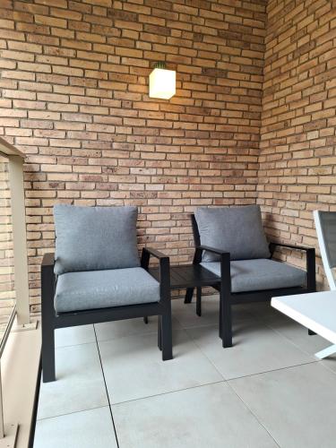 two chairs sitting next to a brick wall at Bartine - modern and spacious flat near the sea, free parking space in Ostend