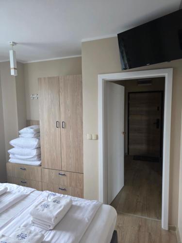a bedroom with a bed and a flat screen tv at Jagodowy Ski&Spa DeLux apartamenty z widokiem na góry,4km od Zieleniec Ski Arena Podgrzewany basen zewnętrzny latem,bilard,Wi-Fi w cenie Restauracja,balia,sauna na miejscu in Lasowka
