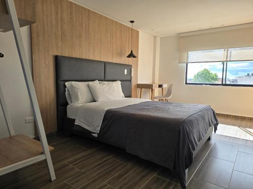 a bedroom with a large bed and a window at Estainn Hotel Coworking in Bogotá