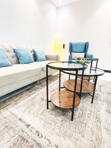 een woonkamer met 2 tafels en een bank bij Boulevard Apartment-H1 in Riyad