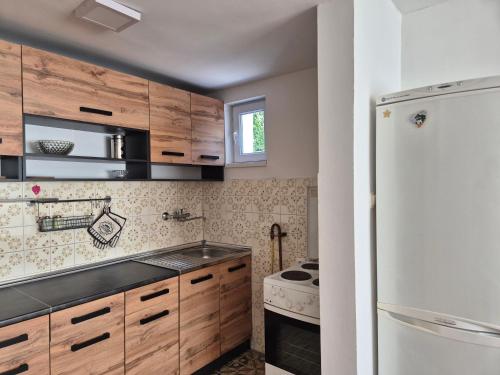 a kitchen with wooden cabinets and a refrigerator at Golden View Apartment in Sarajevo