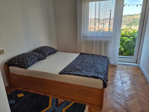a small bed in a room with a window at Golden View Apartment in Sarajevo