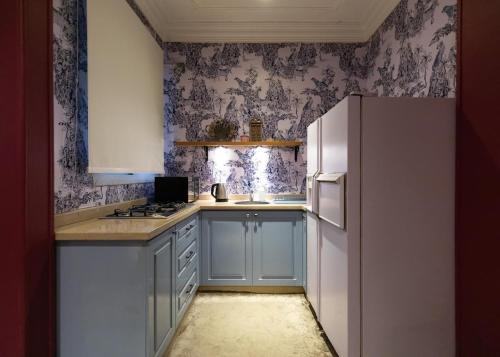 a kitchen with blue cabinets and a white refrigerator at Champollion Khan in Cairo