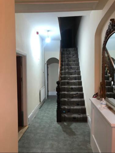 a room with a staircase with a bunch of wine bottles at 106 Brynmill - Room 9 - Sea Views in Sketty
