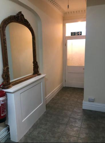 a mirror on a counter in a room with a door at 106 Brynmill - Room 9 - Sea Views in Sketty