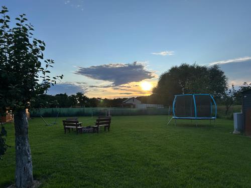 a group of benches and a blue tent in a field at Domki w sadzie Wapnica koło Międzyzdrojów in Wapnica
