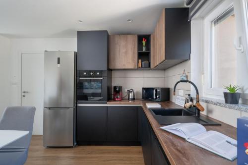 a kitchen with black cabinets and a stainless steel refrigerator at Vita Laboris in Valtura