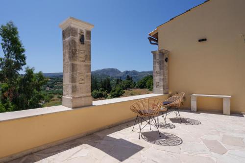 two chairs and a table on a balcony with a view at New Private Apartments by Myre3, just a short drive from Rethymno and the beach in Zourídhion