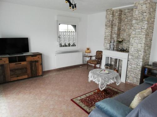 a living room with a couch and a tv and a table at Villa Lindenpark in Naila